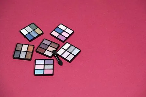 A set of multi-colored eyeshadow on a pink background, copy space for text Stock Photos