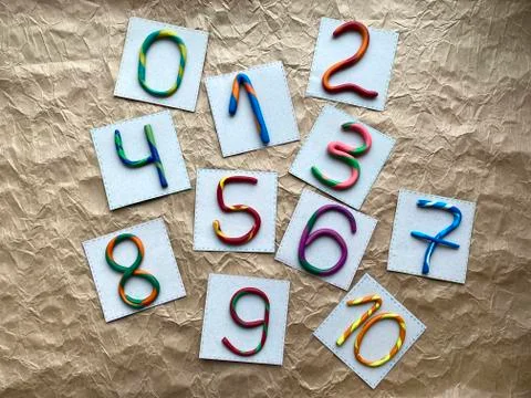 A set of multi-colored numbers made of plasticine, scattered randomly. Stock Photos
