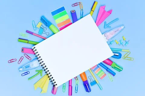 A set of multi-colored school and office stationery laid out under a blank sheet Stock Photos