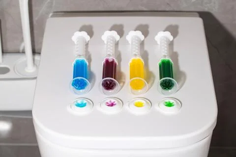 A set of multi-colored syringes with different scents on the toilet bowl in the Foto stock