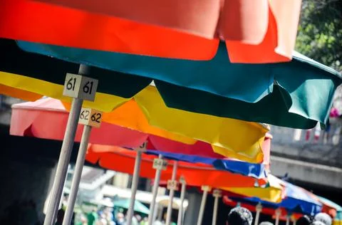 Set of multi-colored umbrellas with table numbers at a restaurant in the Rive Stock Photos