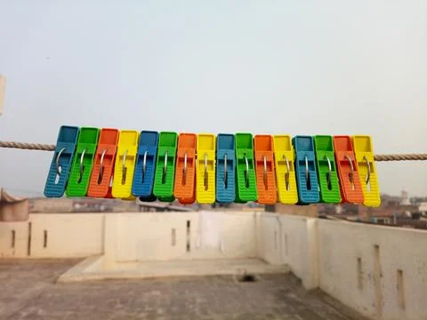 Set of multicolor plastic clothes pins or clothes pegs for house hanging on rope Stock Photos