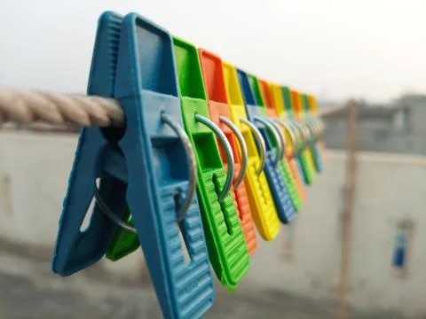 Set of multicolor plastic clothes pins or clothes pegs for house hanging on rope Stock Photos
