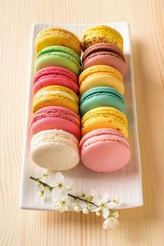 Set of multicolored macaroons and cherry blossom on a rectangular plate. Stock Photos