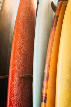 Set of multicolored surf boards in a stack by ocean.Bali.Indonesia. Red, oran Stock Photos