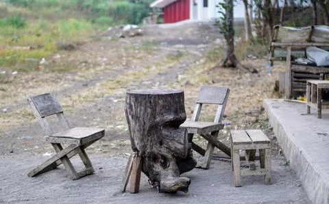 A set of natural tree trunk table and traditional wooden chairs in a rural Stock Photos