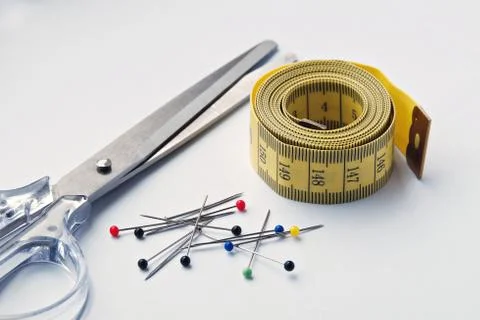 Set for needlework with cissors, measure tape and colored pins Stock Photos