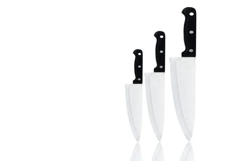 Set of new sharp chef knives with black handle isolated on white background.. Stock Photos