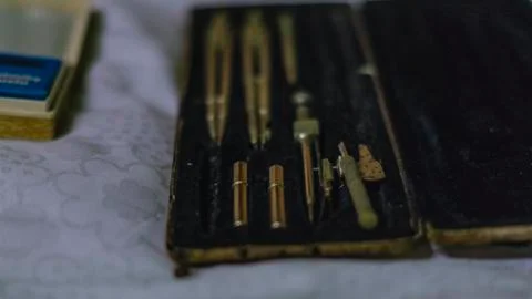 Set of old drawing compasses in a package Stock Photos