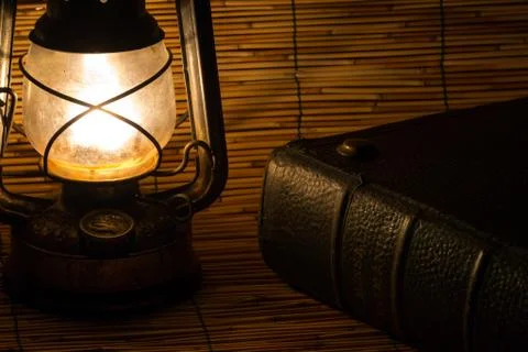 Set with an old rusty lantern and a book Stock Photos
