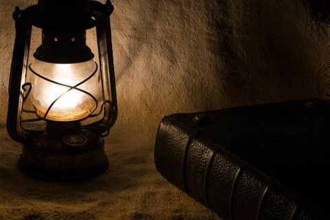 Set with an old rusty lantern and a book Stock Photos