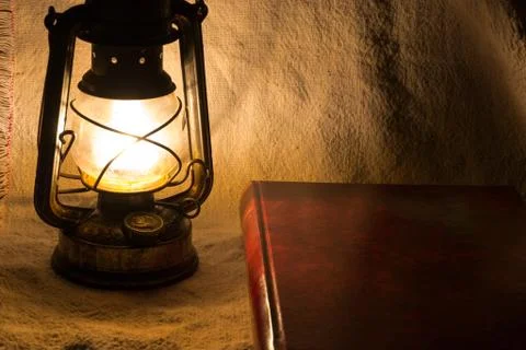 Set with an old rusty lantern and a book Stock Photos
