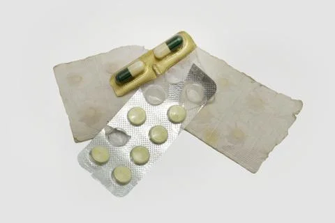 Set of old tablets and bicolor capsules in paper and plastic packaging Stock Photos