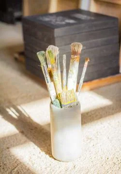 Set of paint brushes in front of canvas Stock Photos