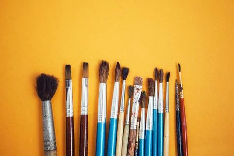 Set of paint brushes on the yellow background Stock Photos