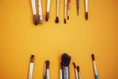 Set of paint brushes on the yellow background Stock Photos