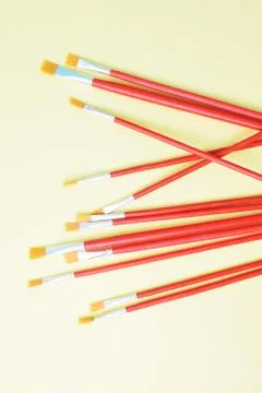 Set of paint brushes on yellow background Stock Photos