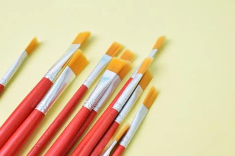 Set of paint brushes on yellow background Stock Photos