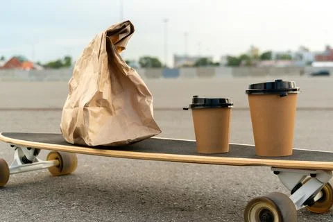 Set with paper bag and two eco friendly coffee cups placed on longboard Stock Photos