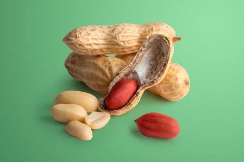 Set of peanuts in a nutshell, unpeeled and peeled peanuts on a green backgrou Stock Photos