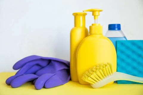 Set of plastic bottles of different cleaning procucts, rubber gloves and sponges Stock Photos