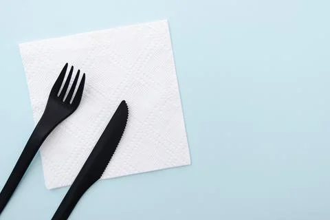 Set of plastic cutlery black fork and knife on white paper napkin Stock Photos