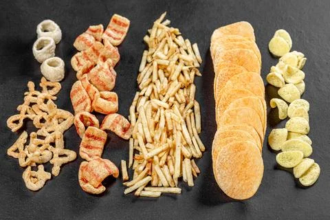 Set of potato snacks and chips on black background Stock Photos