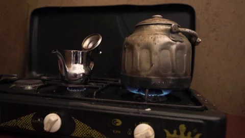 A set of pots making tea are in the heat of the stoves Stock Footage 243572777