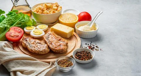 A set of products for making Caesar salad on a gray background with space for Stock Photos