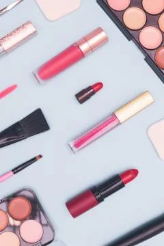 Set of professional cosmetics, makeup tools and accessories on blue background Stock Photos