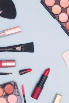 Set of professional cosmetics, makeup tools and accessories on blue background Stock Photos