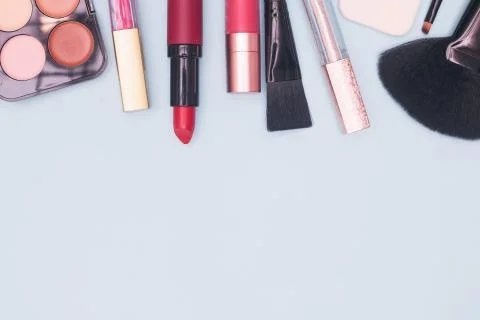 Set of professional cosmetics, makeup tools and accessories on blue background Stock Photos
