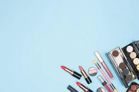 Set of professional cosmetics, makeup tools and accessories on blue background Stock Photos