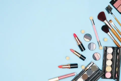 Set of professional cosmetics, makeup tools and accessories on blue background Stock Photos