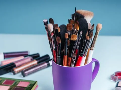 Set of professional makeup brushes on the background of a palette with colored Stock Photos