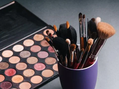 Set of professional makeup brushes on a palette background with colored eye Stock Photos