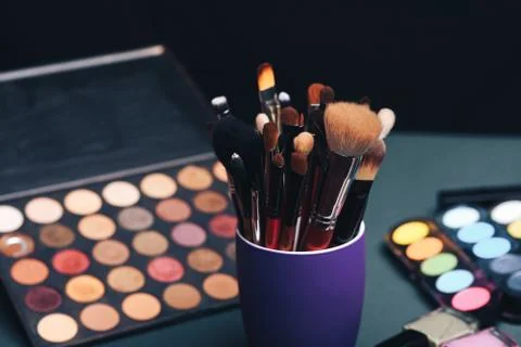 Set of professional makeup brushes on a palette background with colored eye Stock Photos