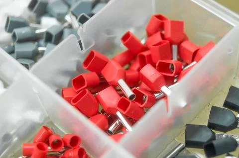 A set of red crimp terminals for electrical wires. Crimping sleeves of different Stock Photos
