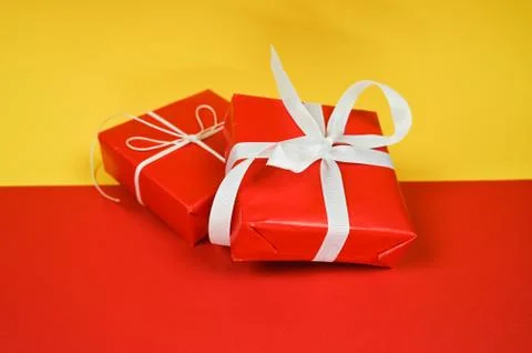 Set of red gift boxes on yellow-red surface with copy space. Stock Photos