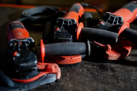 Set of red industrial angle grinders placed on workshop table Stock Photos