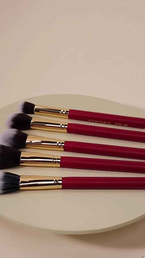 Set of red makeup brushes rotating on a plate Video stock 331773638