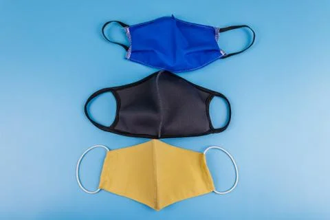 Set of reusable fabric masks on blue background. Top view Stock Photos