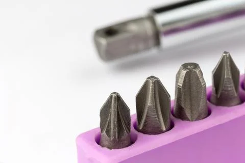 Set of screwdriver bits with screwdriver in the background Stock Photos