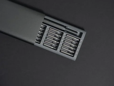 A set of screwdrivers with bits in a case on a dark background. Close up, fla Stock Photos