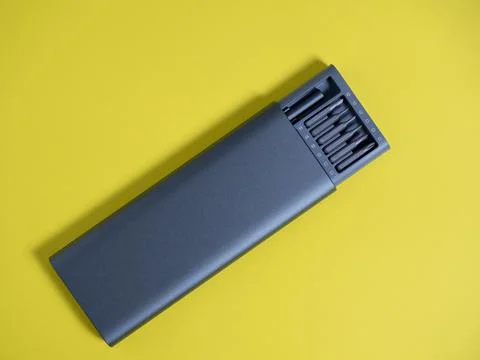 A set of screwdrivers with bits in a case on a yellow background. Tools for w Stock Photos