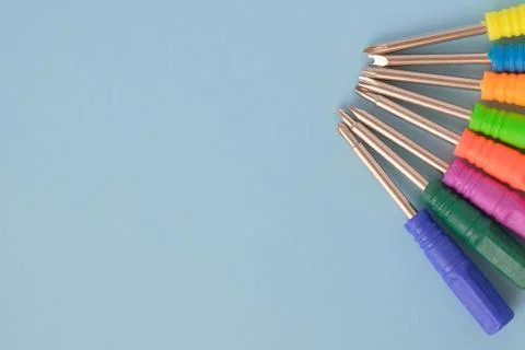 Set of screwdrivers with multi-colored handles on blue background. Fotos de archivo