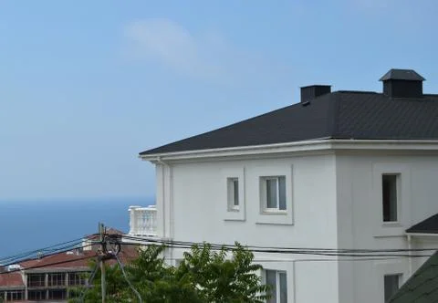 Set on the seafront, this modern cottage features white walls, tiled roofs an Stock Photos
