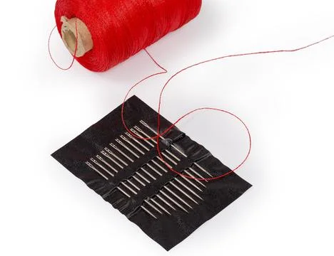 Set of self-threading hand sewing needles against threads spool Stock Photos