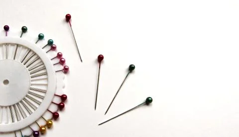 Set of sewing pins with colored beads in an white organizer on a white bg. Stock Photos