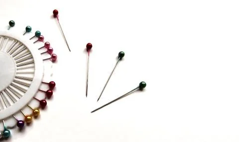 Set of sewing pins with colored beads in an white organizer on a white bg. Stock Photos